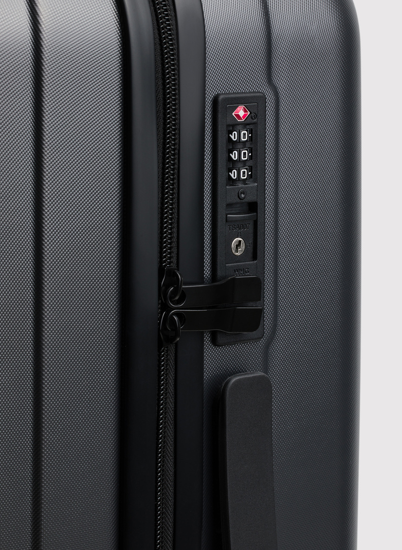 Vidutinis tamsiai pilkas lagaminas su grioveliais